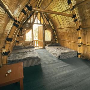 a room with two beds in a bamboo house at Homestay Syariah Tipe A Kadudampit Sukabumi in Citamiang