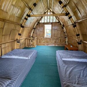a room with two beds in a wooden building at Homestay Syariah Tipe A Kadudampit Sukabumi in Citamiang