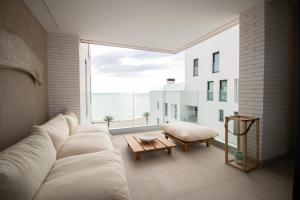 een woonkamer met een bank en een groot raam bij Luxury penthouse with private pool in El Campello