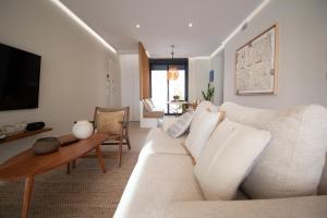 een woonkamer met een witte bank en een tafel bij Luxury penthouse with private pool in El Campello