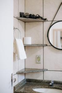 a bathroom with a mirror and a sink at Residencial Mizinho in Florianópolis +126 photos