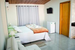 a bedroom with a bed and a television in it at Pousada Bela Vista in Sengés