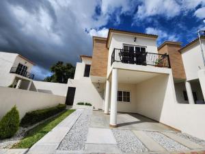 a white house with a balcony on top of it at Casa Jumay Mallorca in Achiotes Jumay