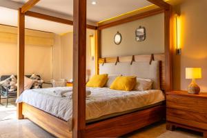 a bedroom with a canopy bed with yellow pillows at Family Condo with 3 Bedrooms Pool & Hot tub in Acapulco +42 photos