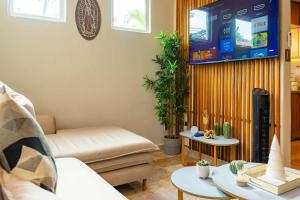 a living room with a couch and a flat screen tv at Family Condo with 3 Bedrooms Pool & Hot tub in Acapulco