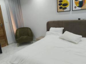 una camera da letto con un letto e una sedia verde di Prince Dikeoha home a Lagos