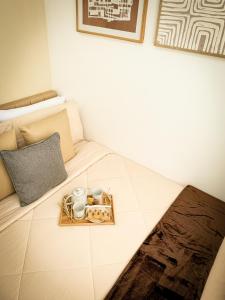 a bed with a tray with two mugs and a tray of food at Natural Haven at South in Manila +9 photos