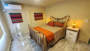 una camera da letto con un letto con una coperta arancione di La Moradita Villa Carlos Paz a Villa Carlos Paz Altre 25 foto