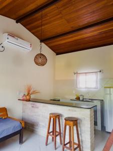 a kitchen with a counter and two stools in a room at Villa Justen Pousada in Lençóis