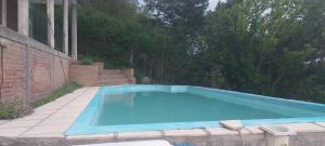 a large blue swimming pool in a yard at Chalet de Montaña a 8 cuadras del centro de Carlos Paz con pileta de 9 x 4 in Villa Carlos Paz