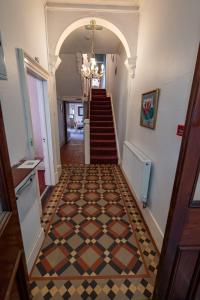 a hallway with a staircase with a checkered floor at Isfryn Holiday Let in Caernarfon