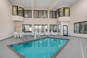 a pool in a house with chairs and a table at Comfort Suites Hattiesburg near University in Hattiesburg