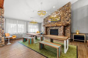a living room with a fireplace and tables and a couch at Spark by Hilton Cedar Falls in Cedar Falls