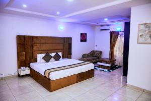 a bedroom with a large bed and a chair at Executive Luxury Room - Sleeps 2 - Pool - Gym in Lagos