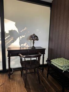 a desk with a lamp and a chair in a room at Tropical eglamping in Tân Phú