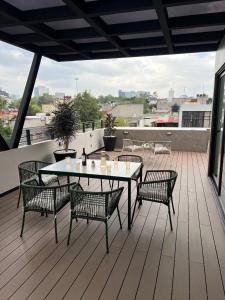 een terras met een tafel en stoelen op een dak bij Pánuco Suites in Mexico-Stad