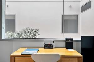 a kitchen with a wooden table and white cabinets at Gibson Mill waterfront warehouse apartment - 204 in Hobart