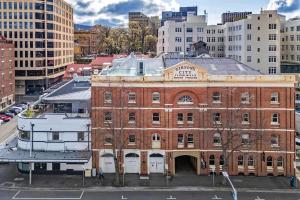 an old brick building in the middle of a city at Gibson Mill waterfront warehouse apartment - 204 in Hobart +16 photos