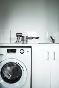 a washing machine with a pot on top of it at Orion Beach Cottage B - Jervis Bay in Vincentia +5 photos