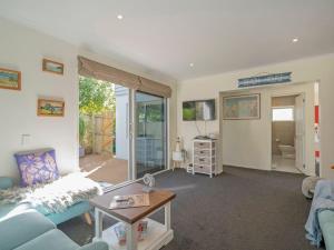 a living room with a couch and a table at Hosts on the Coast Beach on Buffalo in Whitianga