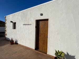 a white building with a wooden door on it at Apartamentos Violante in Tuineje