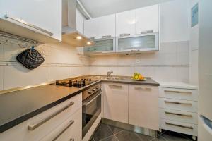 a kitchen with white cabinets and a sink at Apartments Milica in Krilo