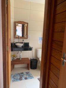 a bathroom with a sink and a toilet and a mirror at Casa Sempre Viva in Caraíva +32 photos