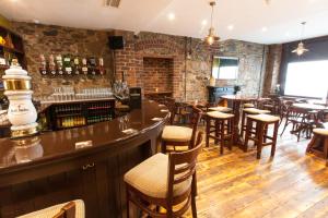 a bar in a restaurant with tables and chairs at The Rostrevor Inn in Rostrevor