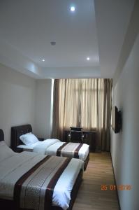 een hotelkamer met 2 bedden en een raam bij Qu Lin Resident in Sibu