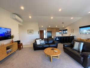 a living room with a couch and a table at Four Lakes Retreat in Twizel