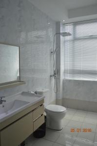 y baño con aseo, lavabo y ducha. en Qu Lin Resident, en Sibu