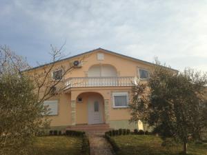 a yellow house with a balcony on top of it at Apartments Brkanac in Umag