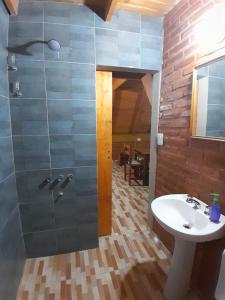 un bagno con lavandino e doccia in vetro di Cabaña Coralina a Bialet Massé