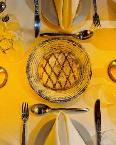 a table with a yellow table cloth with a plate of pie at Riad Chay & Boutique in Ouarzazate