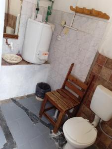 a bathroom with a toilet and a chair in it at Posada del Valle in San Agustín de Valle Fértil +20 photos