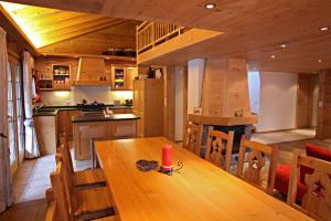 eine Küche und ein Esszimmer mit einem Holztisch in der Unterkunft Chalet Diana in Le Sépey