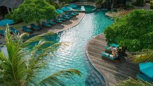a lazy river at a resort with people on a raft at Vila Ombak in Gili Trawangan