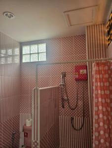 La salle de bains est pourvue d'une douche avec du carrelage rouge et blanc. dans l'établissement Khaoyaitriplefive, à Ban Thung Sawang