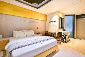 浦项Pohang Cheongha Call Self Check-in Motel的带一张大床和一张桌子的卧室
