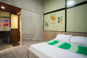 a bed in a room with a sign on the wall at La Zeblin Beach House in Zambales +63 photos