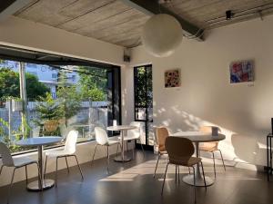 a room with tables and chairs and a large window at The Celestrail - Check-In by Appointment Only Non-Hotel Private Apartment Onnut BTS in Amphoe Phra Khanong