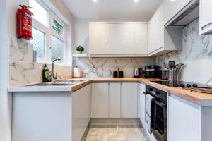 Una cocina con gabinetes blancos y un fregadero. en Cozy Room 4, en Oxford 13 fotos más