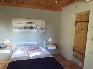 a bedroom with a bed and a painting on the wall at La Ruette aux Loups in Collonges-au-Mont-dʼOr