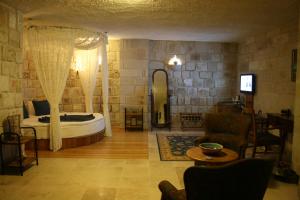 Un dormitorio con una cama y una sala de estar. en Goreme Inn Hotel Only Adult, en Göreme 60 fotos más