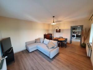 a living room with a couch and a table at Chez Arnaud sauna et jacuzzi in Saint-Jean-Saint-Maurice-sur-Loire