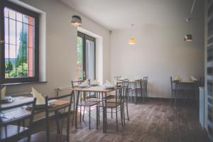 a dining room with tables and chairs and windows at Diás Panzió in Orfű +35 photos