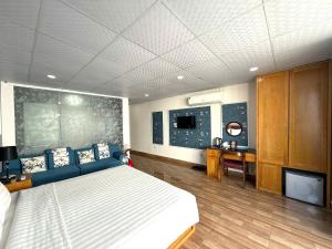 a bedroom with a large bed and a desk at Holiday Suites Hotel & Spa in Hanoi