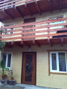 una casa con una terraza de madera sobre una puerta en U Karoliny en Yaremcha