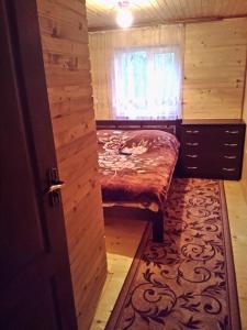 a small bedroom with a bed and a window at U Karoliny in Yaremche
