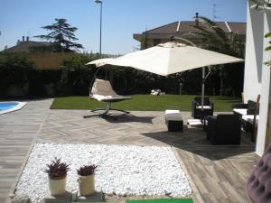 een patio met een stoel en een parasol bij Casa Vacanze Domusangela in Matera